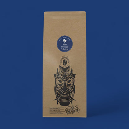 Verpackung der Blue Premium Selection von Costa Rica Kaffee vor einem intensiven blauen Hintergrund. Das kunstvolle Boruca-Design auf der Verpackung spiegelt die Nachhaltigkeit und hochwertige Arabica-Mischung der Granados Farm wider.